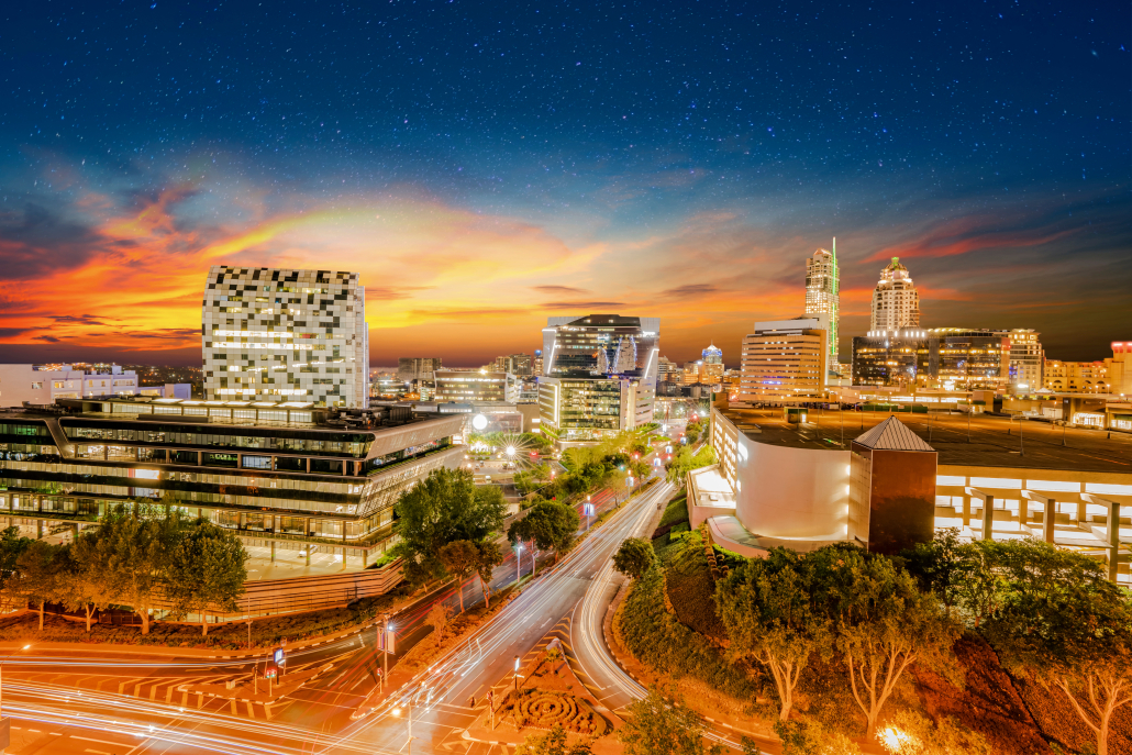 Sandton City lit up at night with colourful clouds and stars in the sky